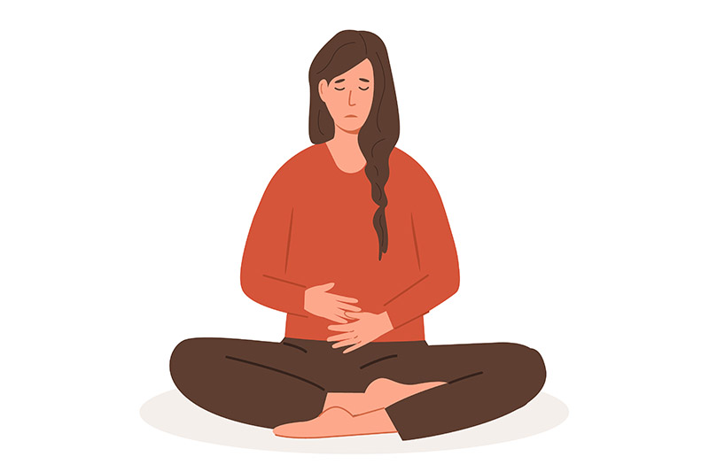 Ilustração de mulher sentada no chão com as pernas cruzadas e mão sobre a barriga. Seu rosto tem feição de dor e desconforto. A dor pélvica é um dos sintomas da hematometra
